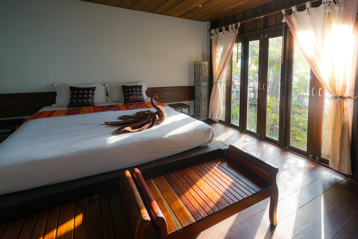 Kamar terang dengan pintu kaca ke kebun kelapa dan bak rendam batu.