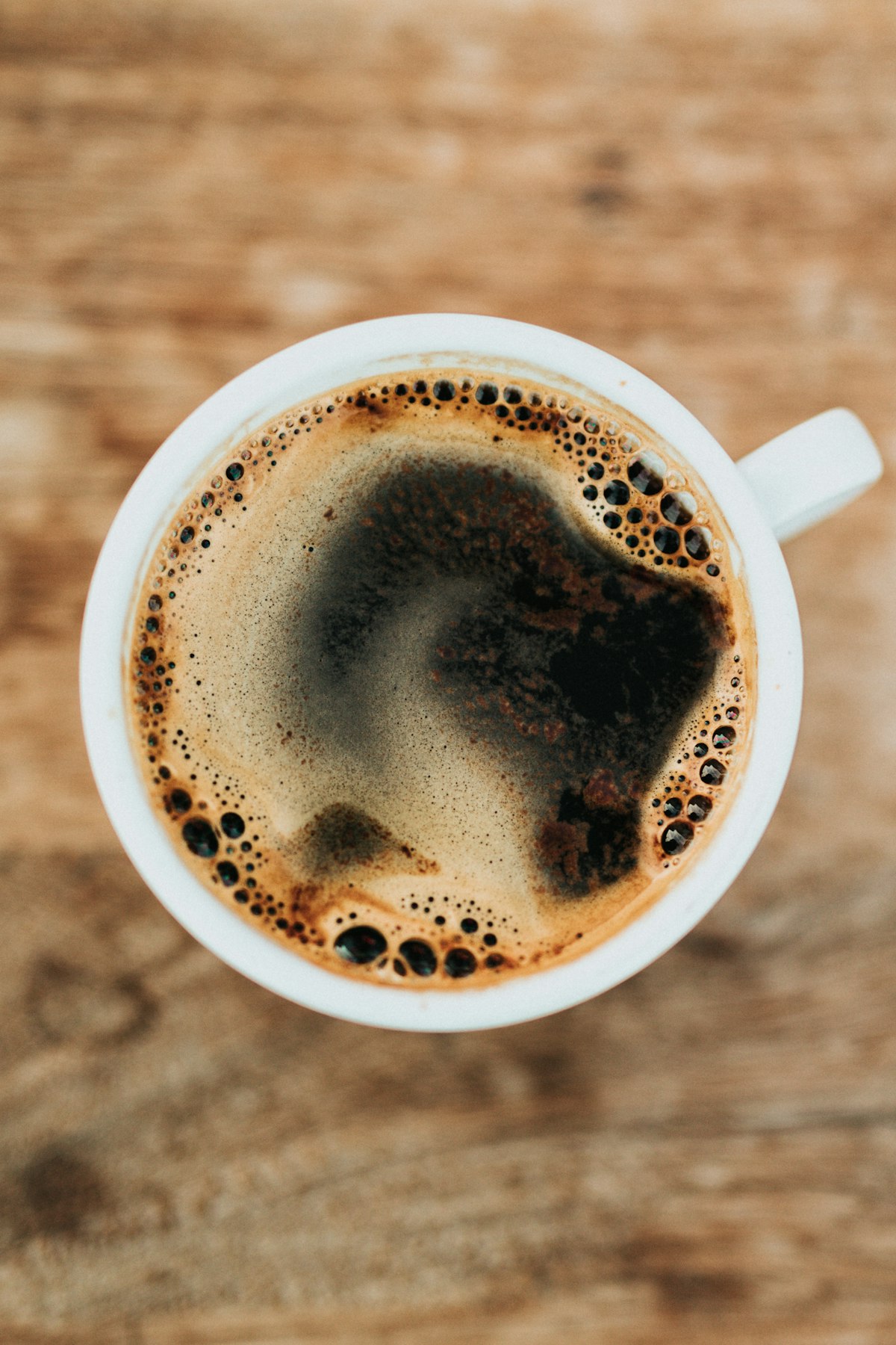 Secangkir Kopi Latte Art Hangat dan Crema Emas di Meja Kayu Kala Seduh